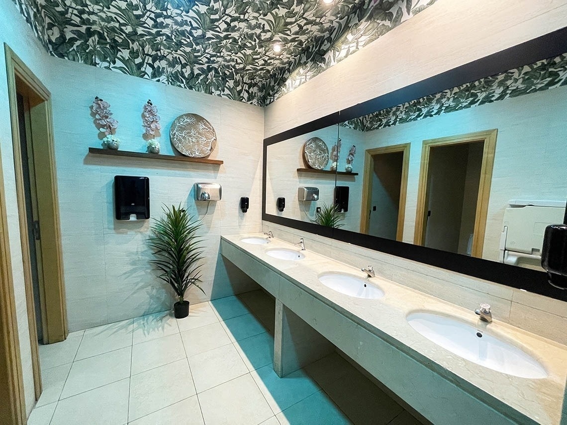a bathroom with three sinks and a large mirror