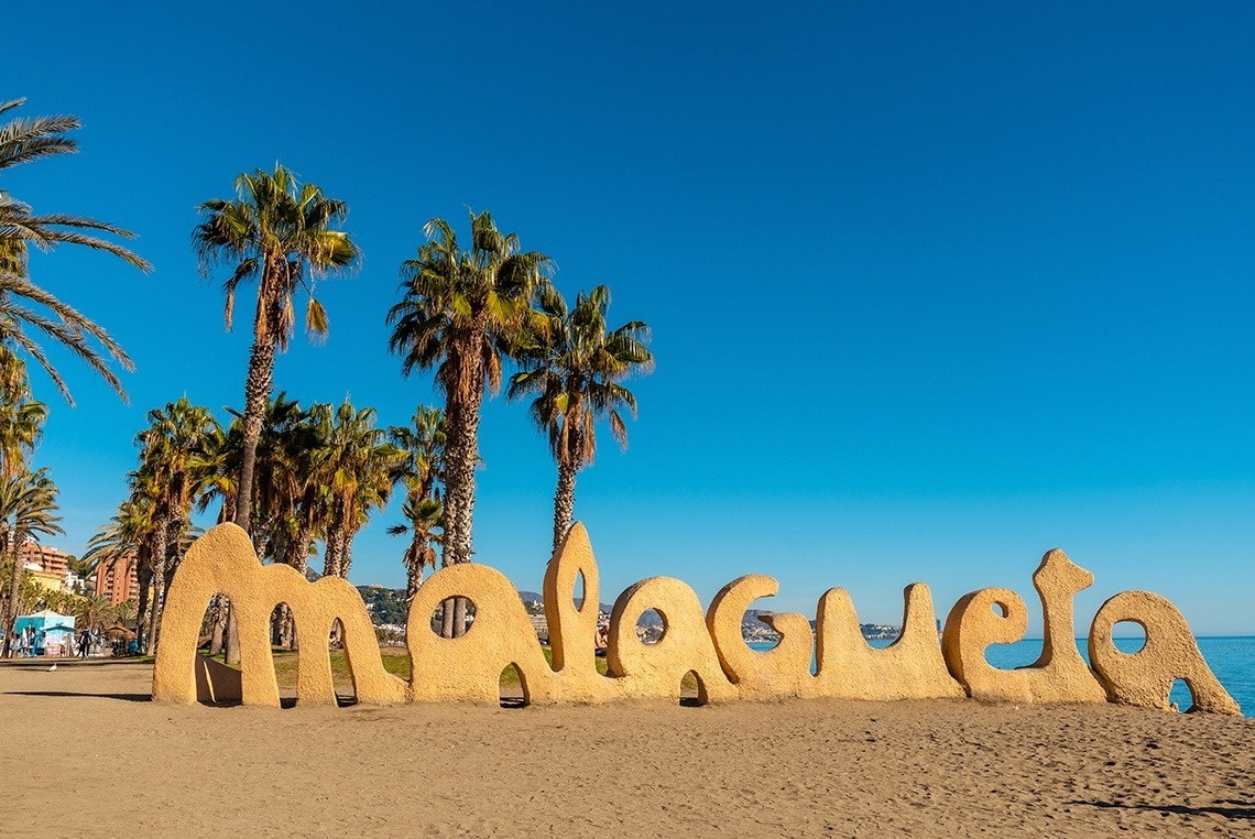 a sign on a beach that says malaga