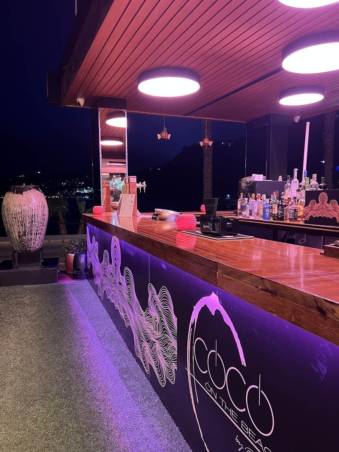 a bar called coco on the beach is lit up at night