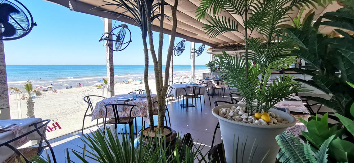 un restaurante con mesas y sillas en la playa