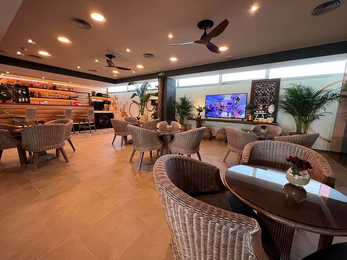 a restaurant with wicker chairs and tables and a tv on the wall