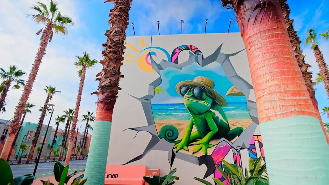 a mural of a chameleon wearing sunglasses and a hat