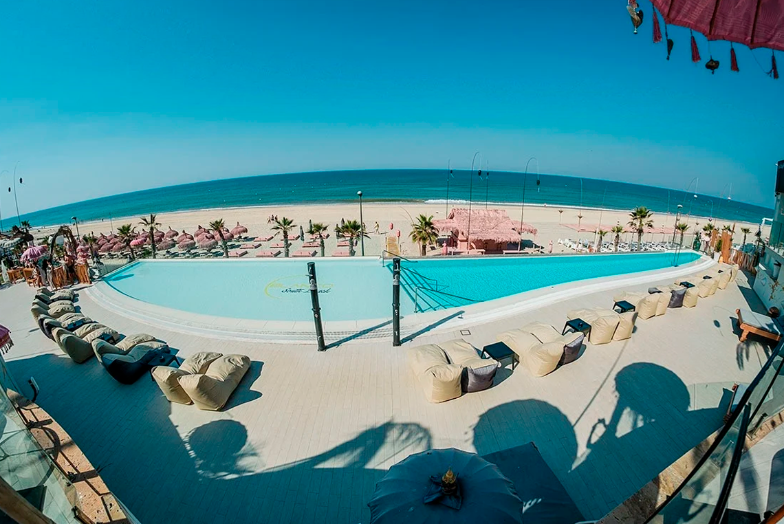 a large swimming pool surrounded by chairs and umbrellas with a sign that says ' aerial ' on it