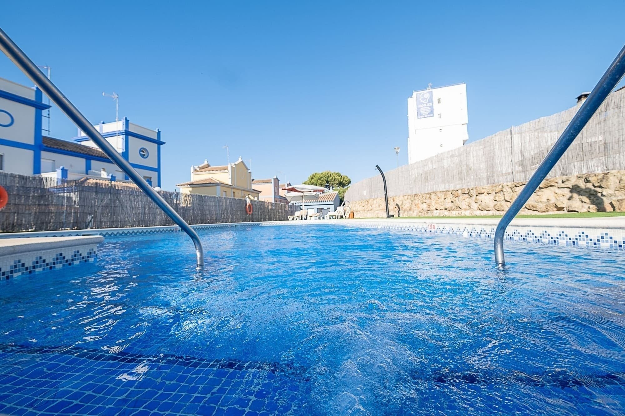 une piscine avec un bâtiment bleu et blanc en arrière-plan