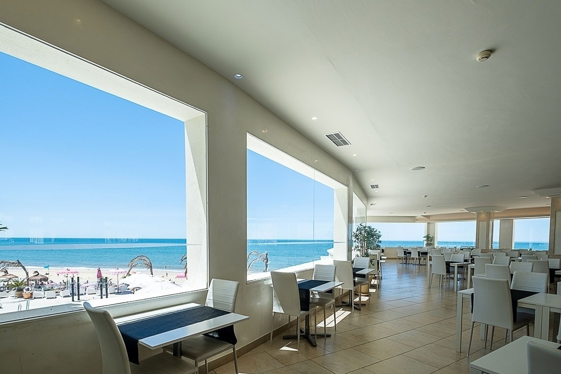 un restaurante con mesas y sillas y una vista al océano