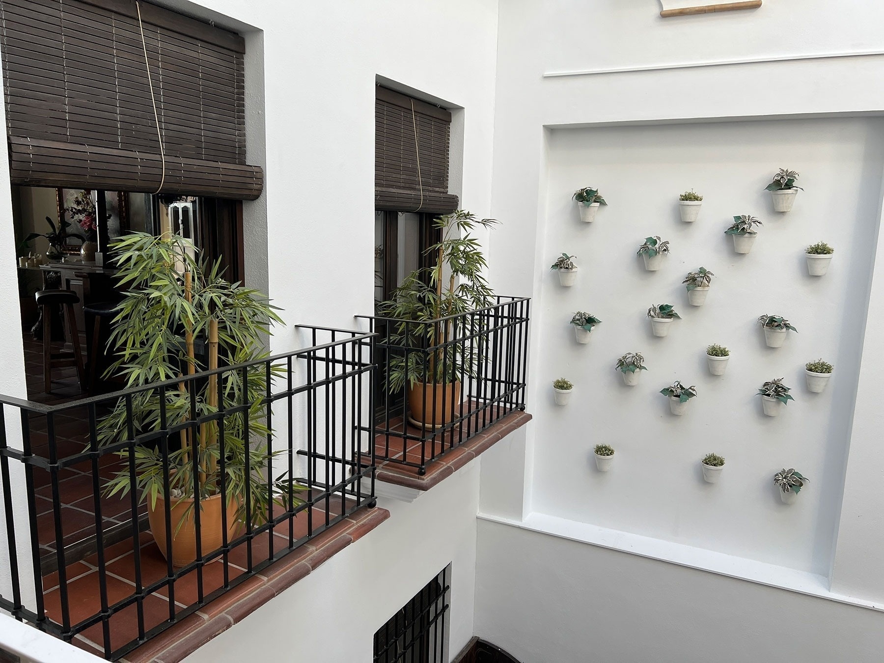 un balcón con muchas macetas de plantas en él