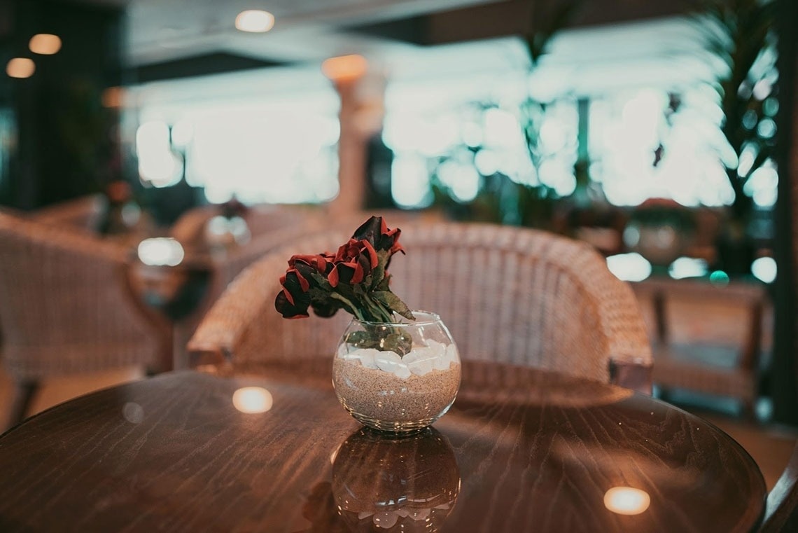 rosas rojas en un jarrón de vidrio sobre una mesa de madera