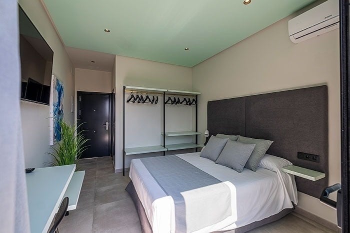 a bedroom with a large bed and a samsung air conditioner