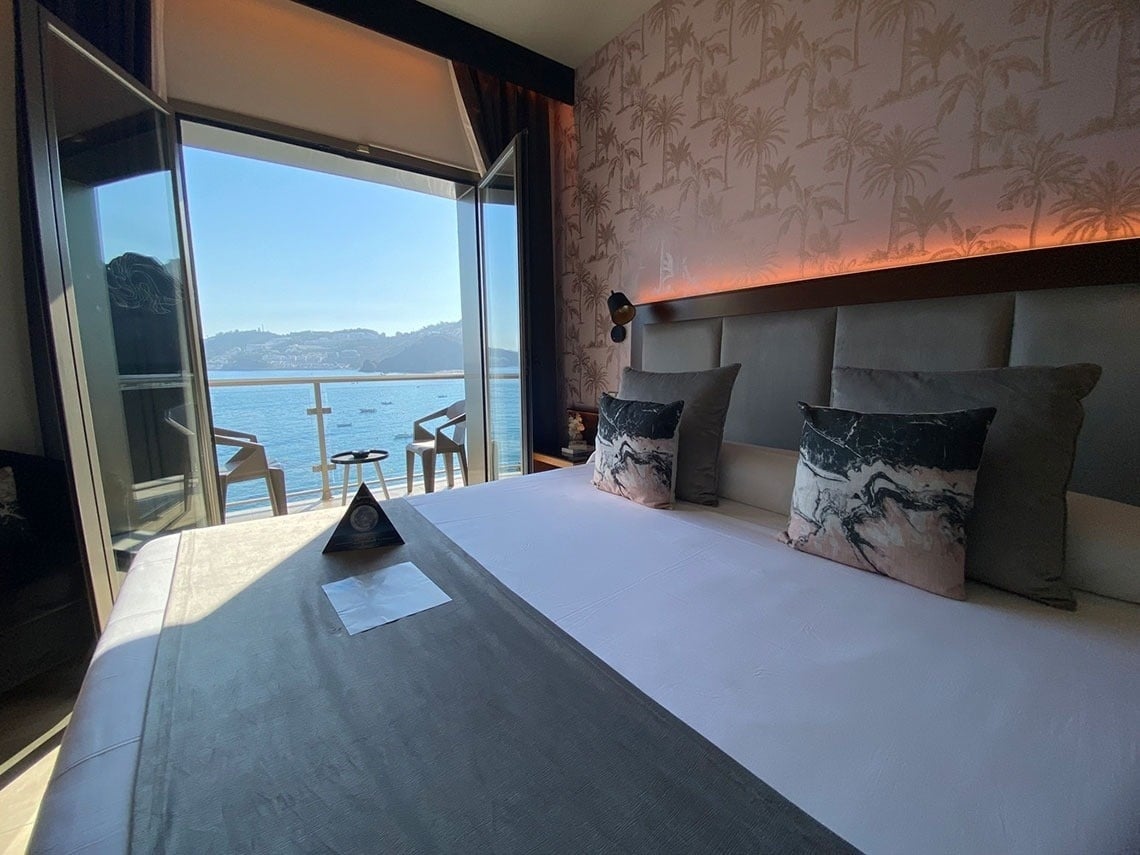 a hotel room with a large bed and a view of the ocean