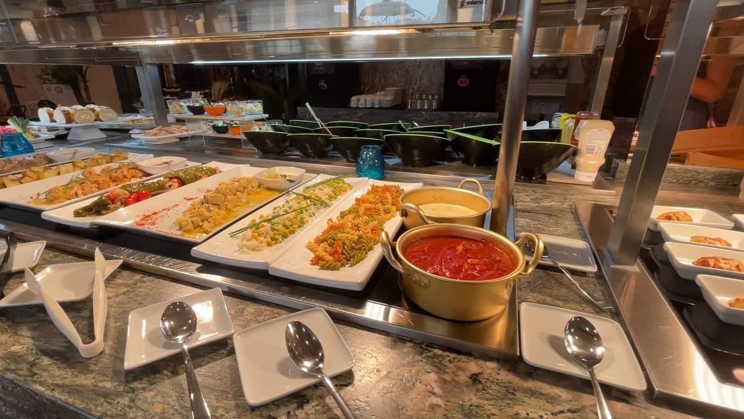 a buffet line filled with a variety of food including sauces