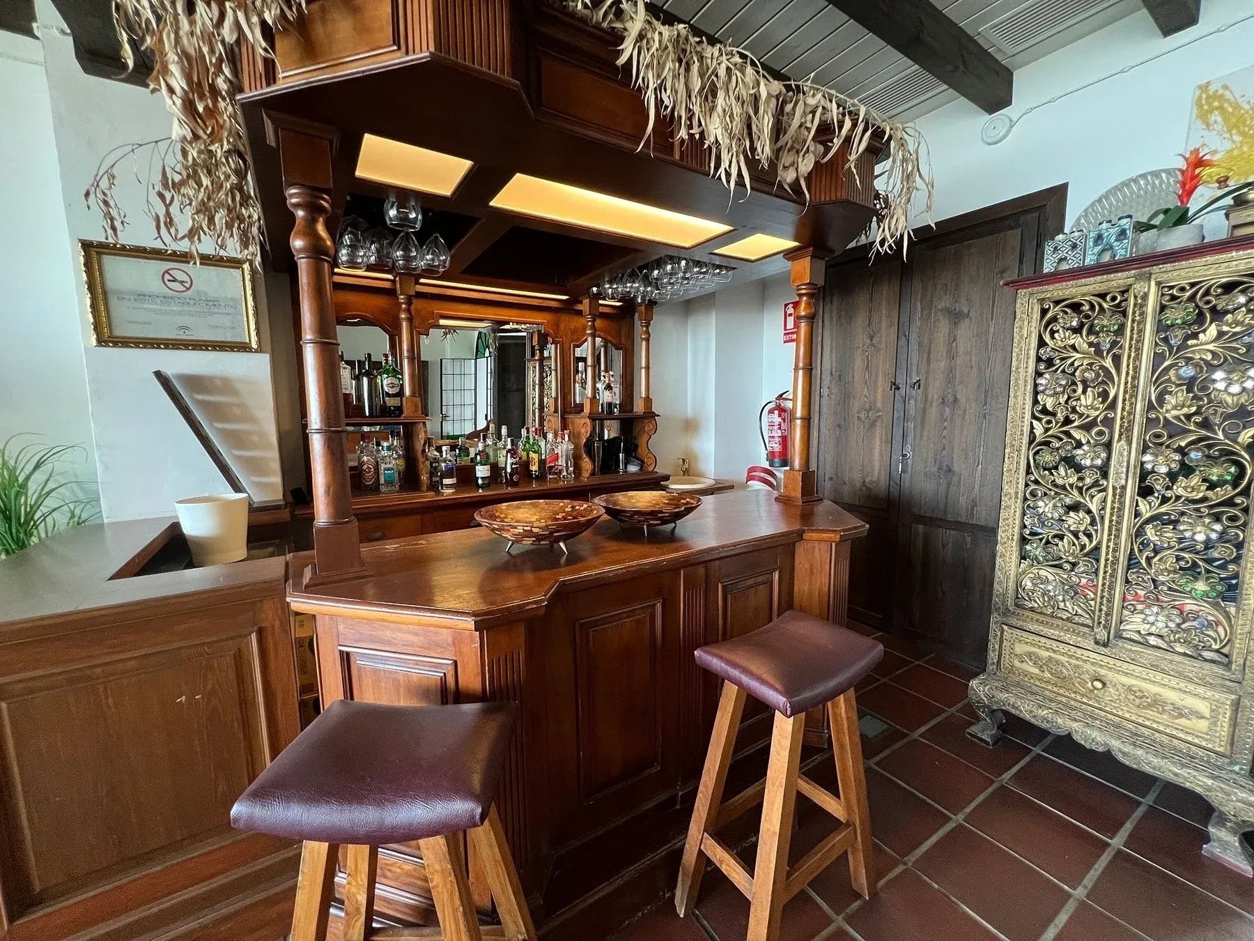 un bar de madera con taburetes marrones en una habitación