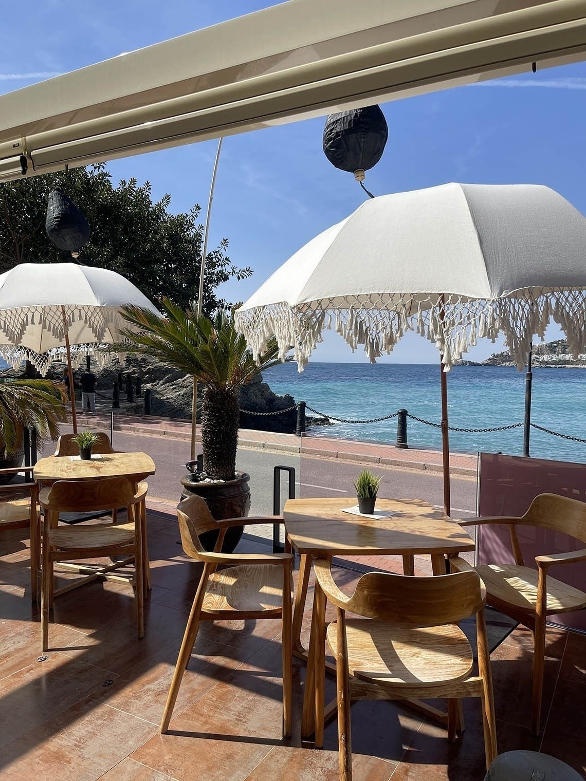 tables and chairs with umbrellas overlooking the ocean