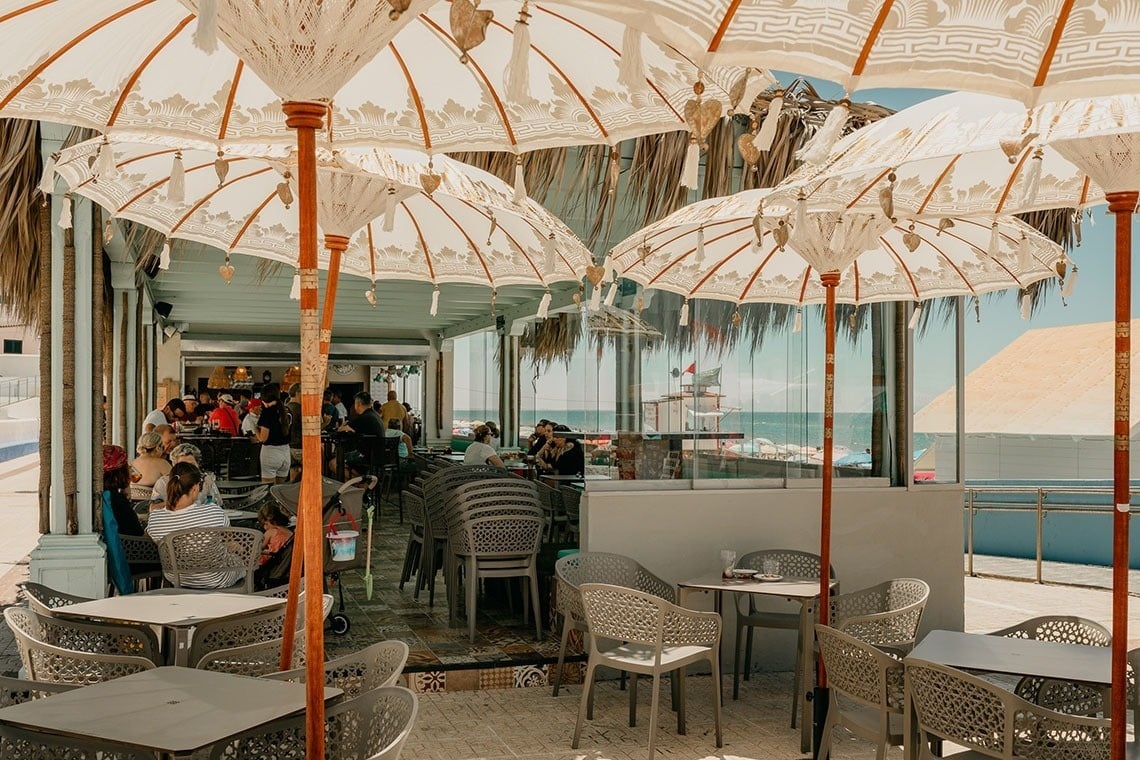 deux cocktails avec des parapluies sont assis à côté d' une piscine