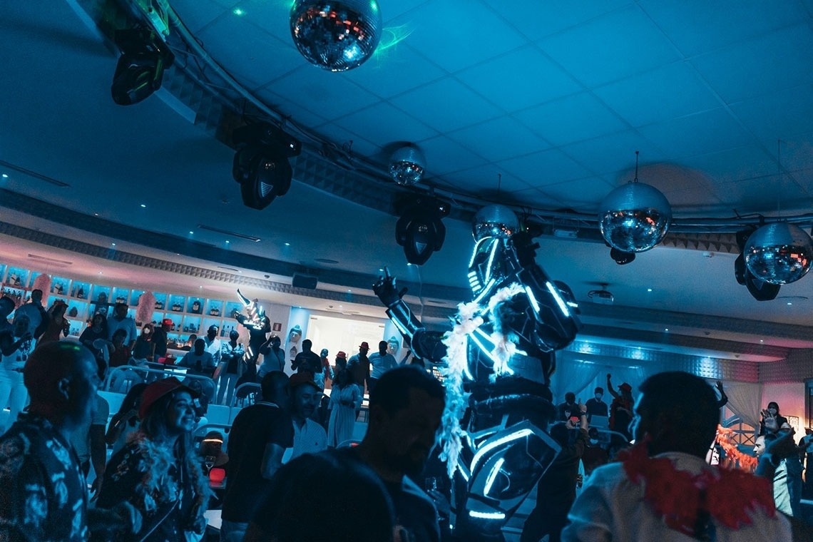 a man in a robot costume is dancing in a crowded room
