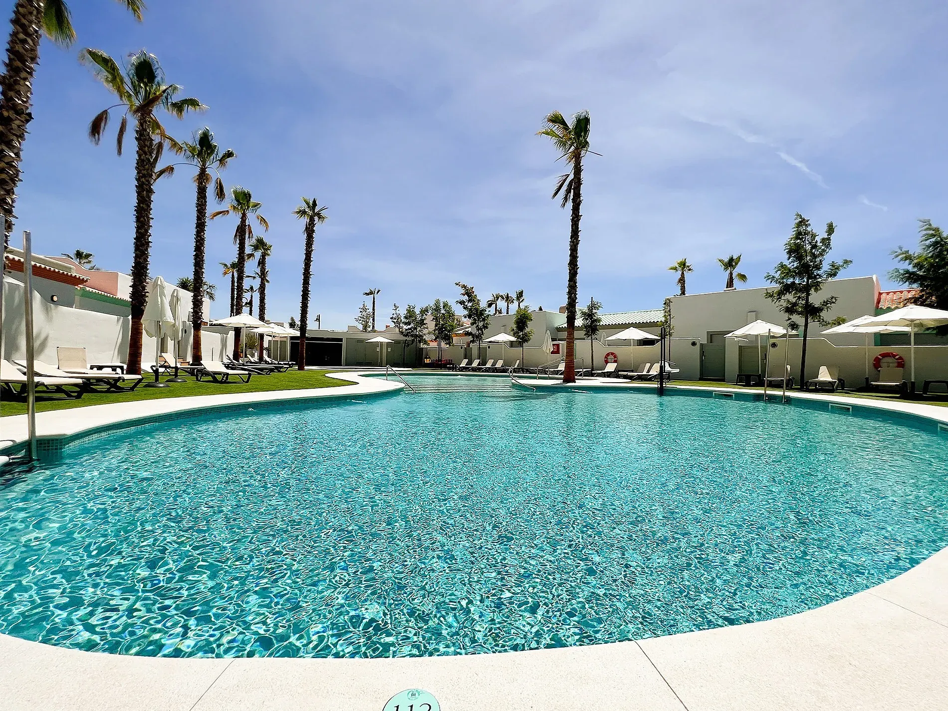 Piscina con palmeras en ON City Apartments | Entorno natural de Doñana | On Hotels