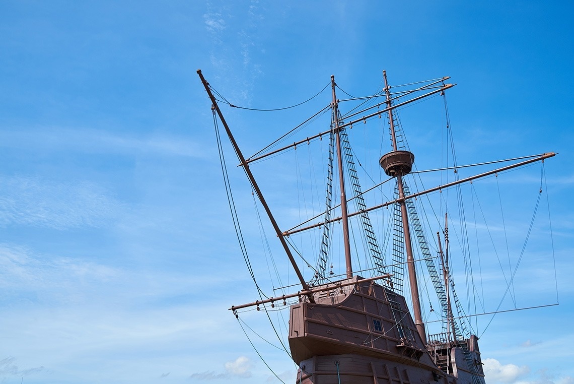 un barco marrón con muchas velas contra un cielo azul