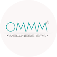 the ommm wellness spa logo is in a circle on a white background .