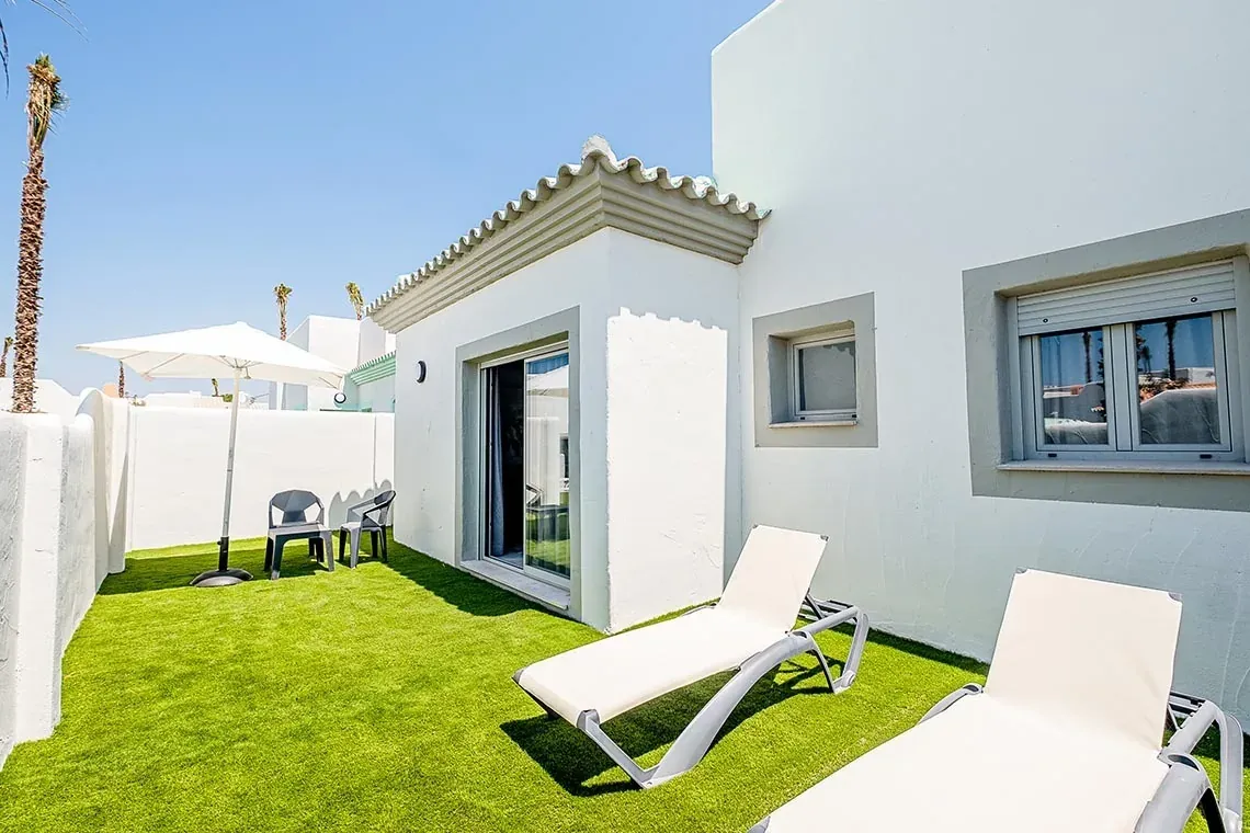 Jardín privado con tumbonas y sombrilla en ON City Apartments, Entorno natural de Doñana.