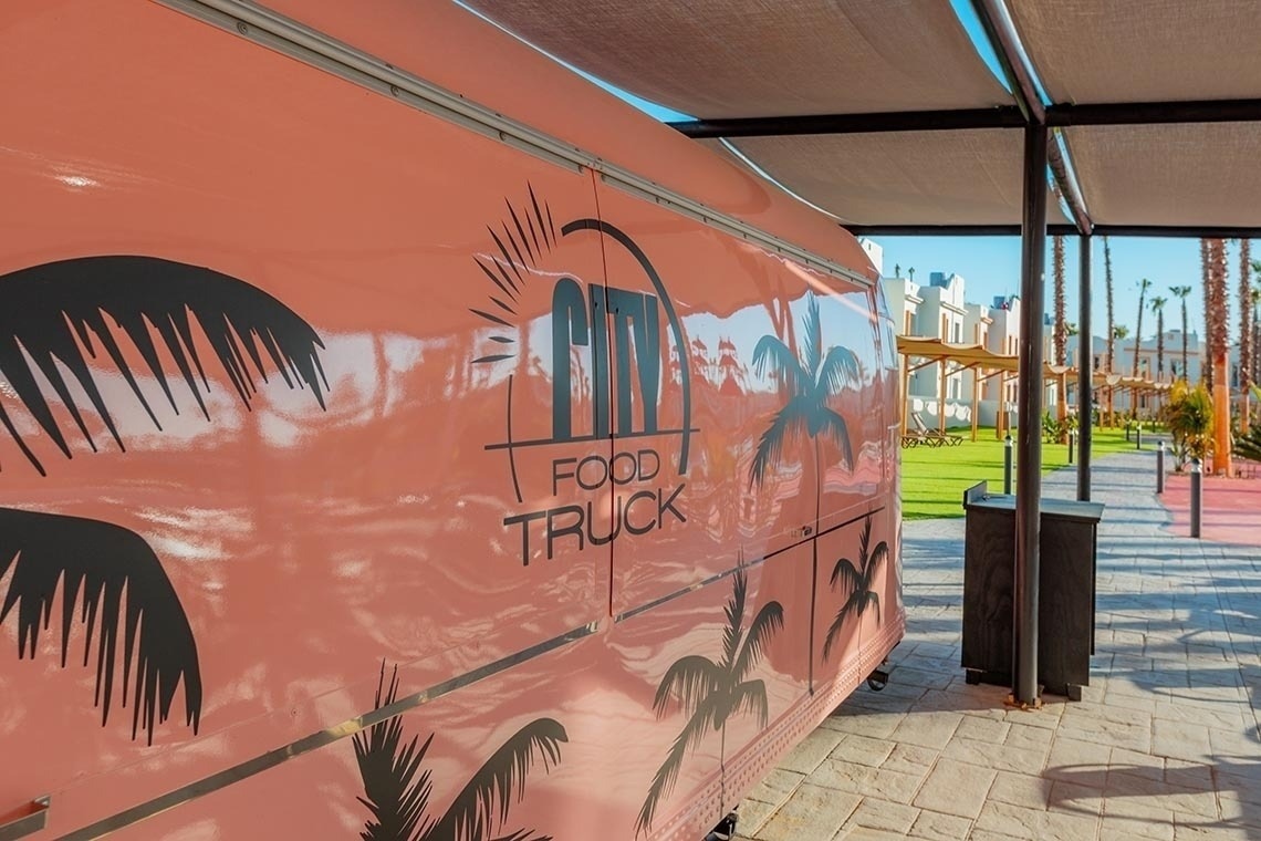 tables and chairs are set up in front of a food truck
