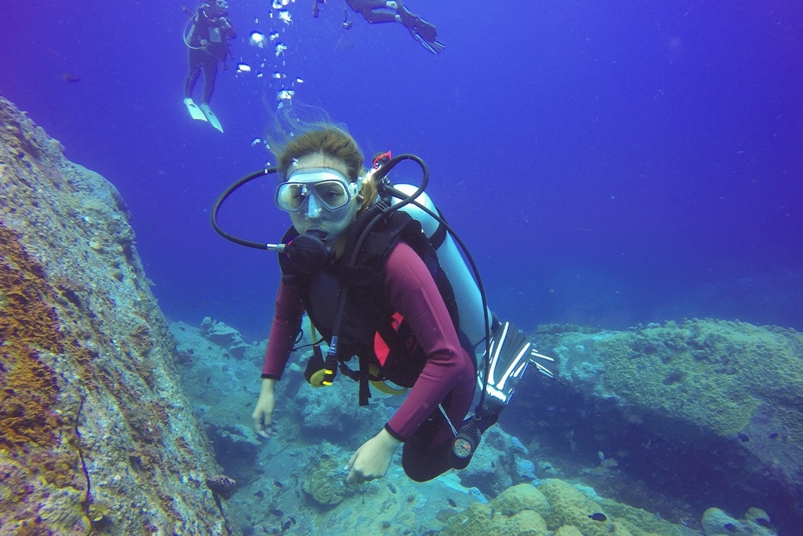 eine Frau in einem Tauchanzug schwimmt im Ozean