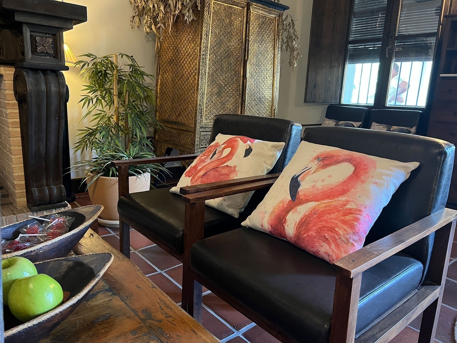 two black chairs with flamingo pillows on them