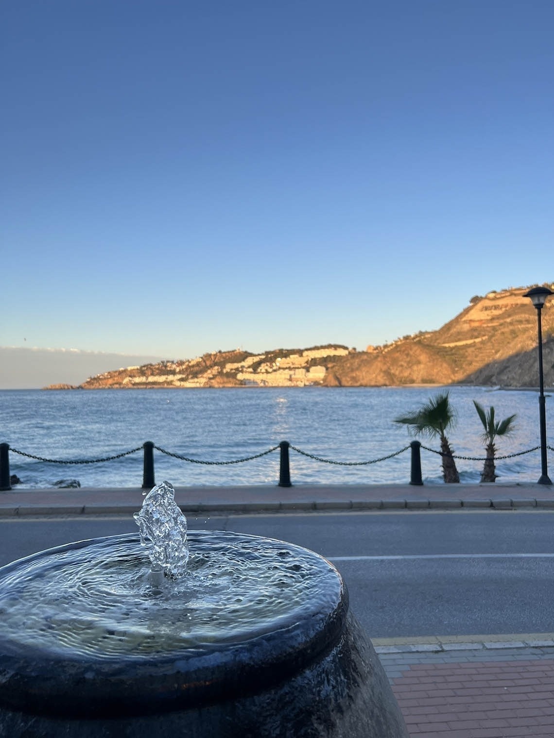 a fountain with a view of the ocean in the background