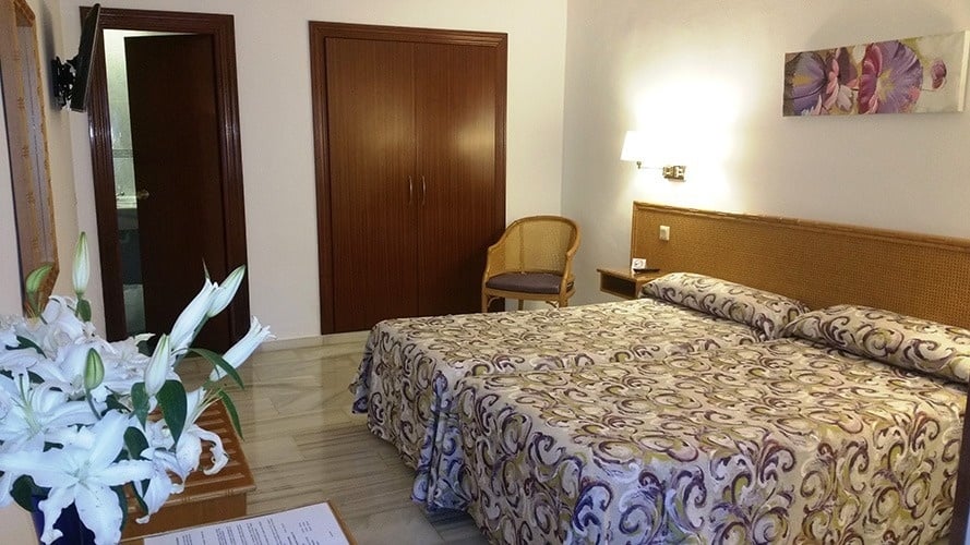 ein Hotelzimmer mit zwei Betten und einem Stuhl