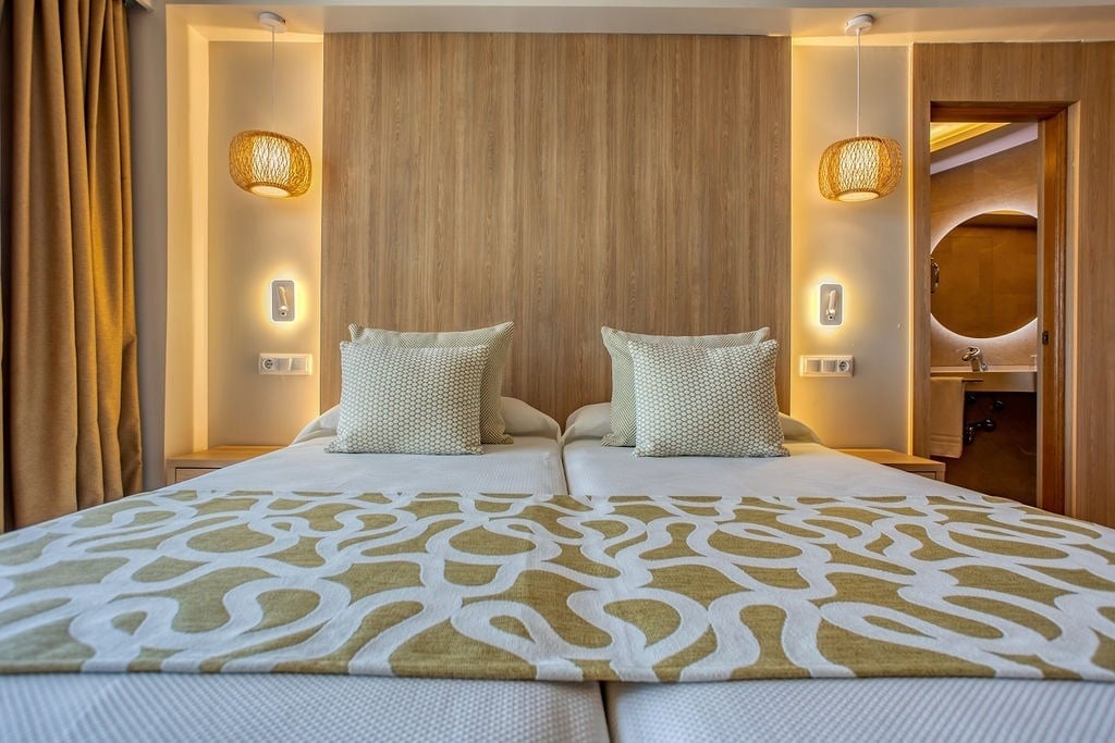 una habitación con dos camas y una pared de madera