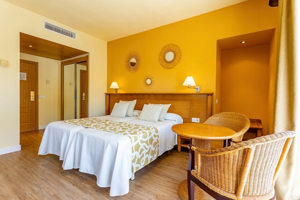 a hotel room with yellow walls and a bed