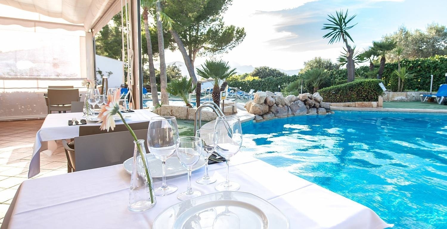 Detalle de mesa con piscinas de fondo del hotel Ona Aucanada al Norte de Mallorca 