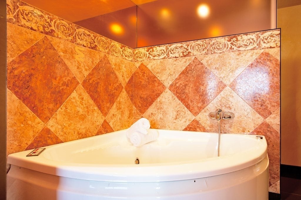 a bathtub in a bathroom with a checkered wall