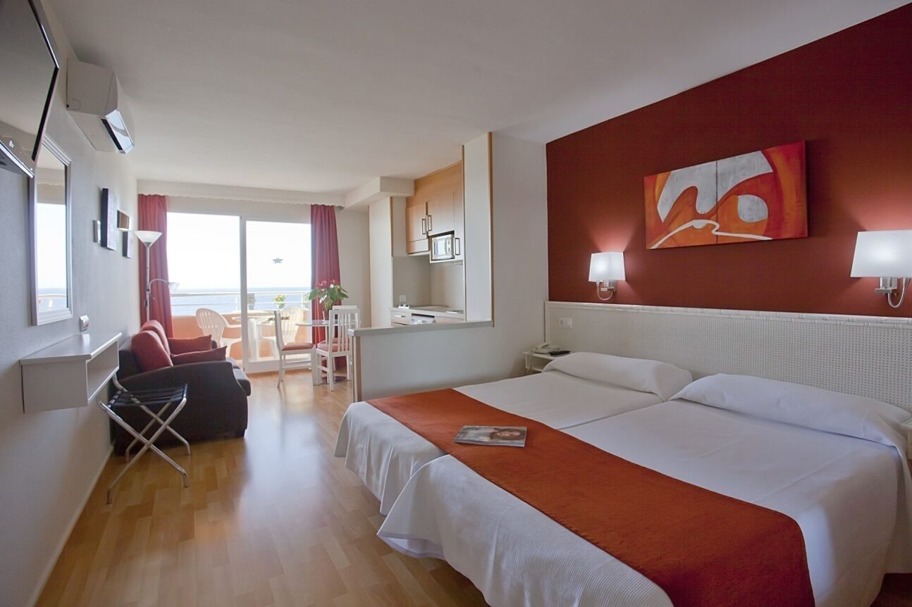 ein Hotelzimmer mit zwei Betten und einem Gemälde an der Wand