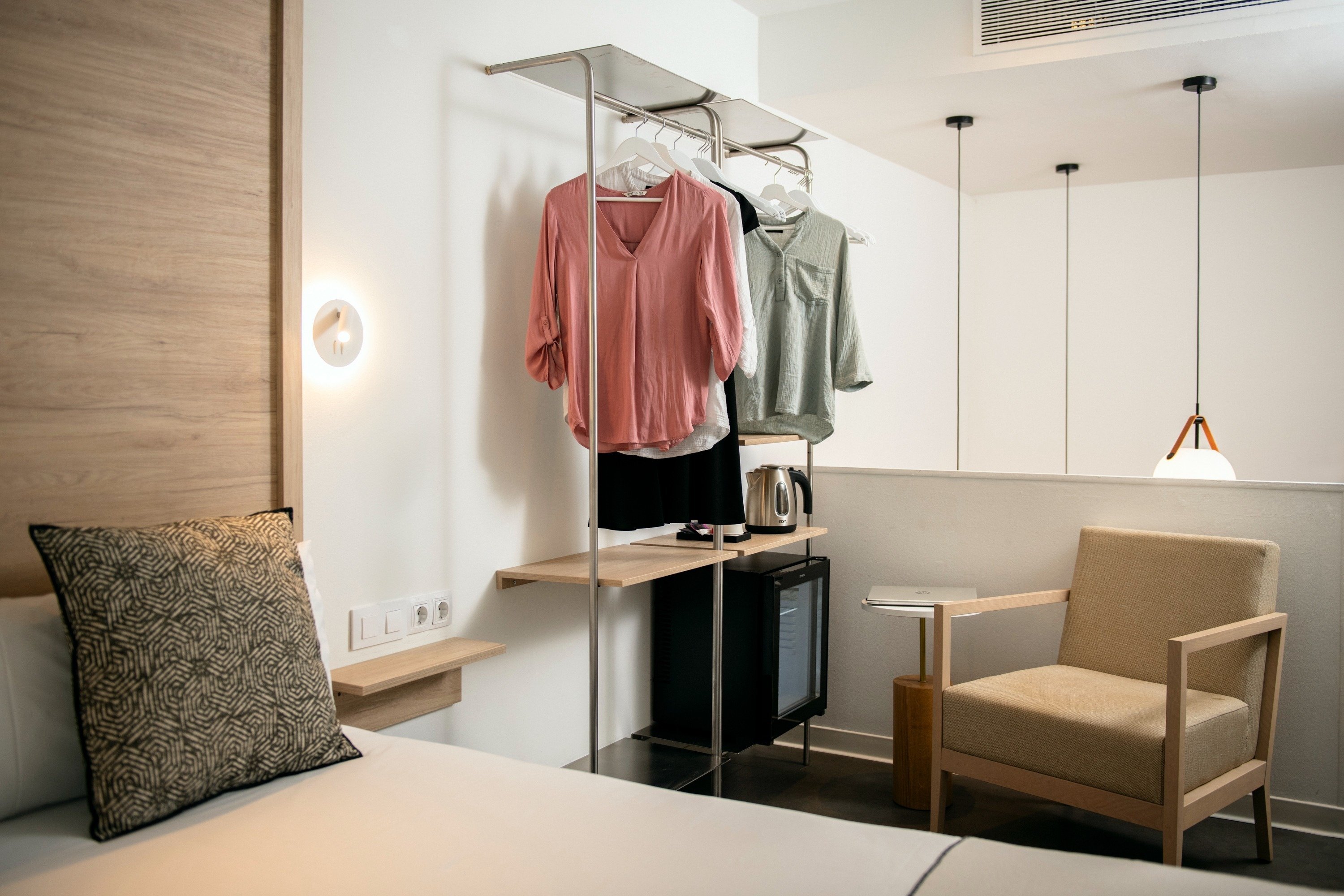 a bedroom with a chair and a clothes rack