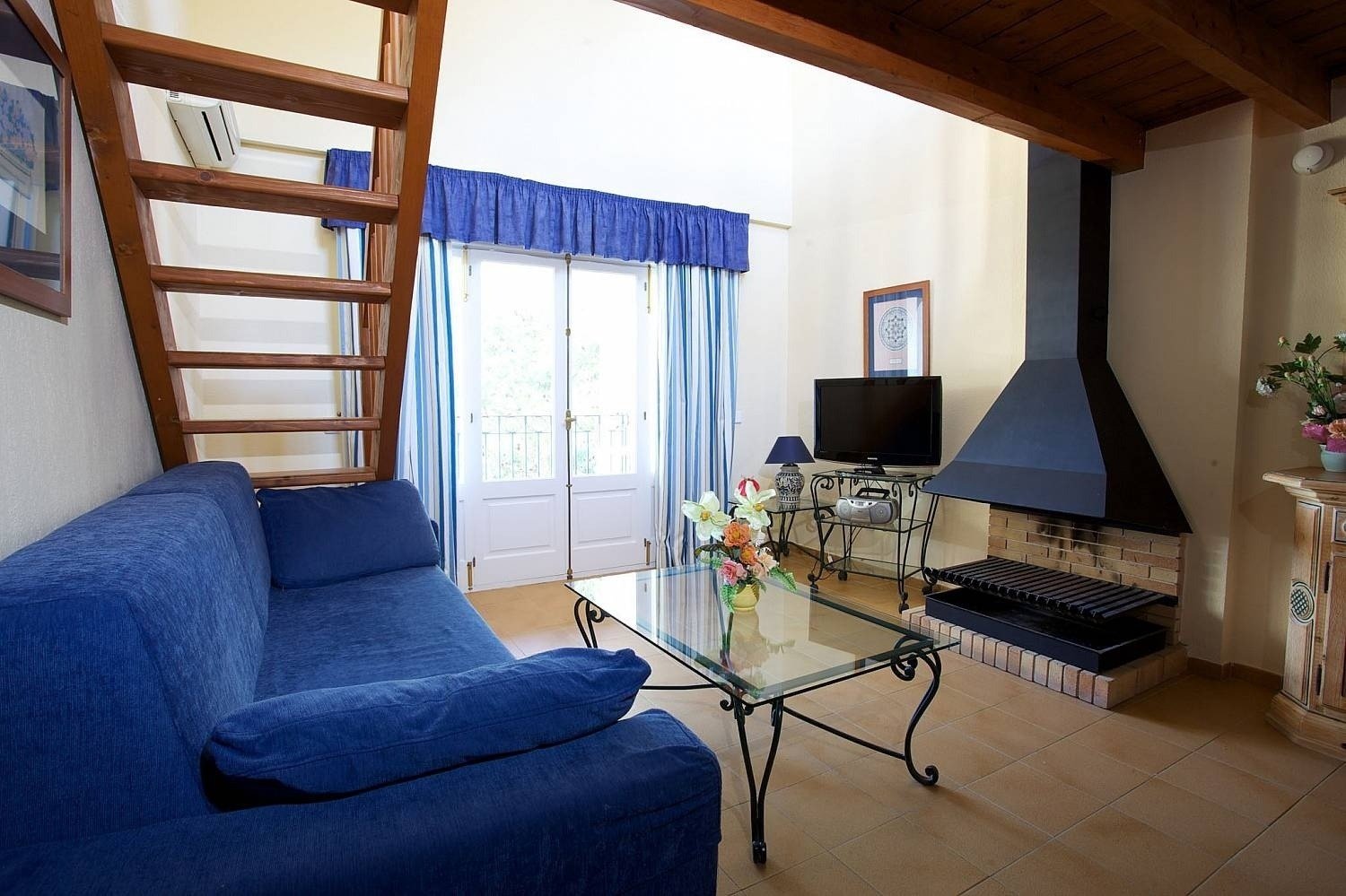 Wohnzimmer mit Kamin im Apartment des Hotels Ona Cala Pi auf Mallorca