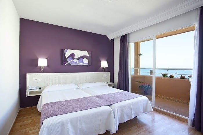 a hotel room with purple walls and two beds