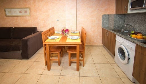 Table avec chaises et cuisine à l´hôtel Ona Jardines Paraisol à Salou