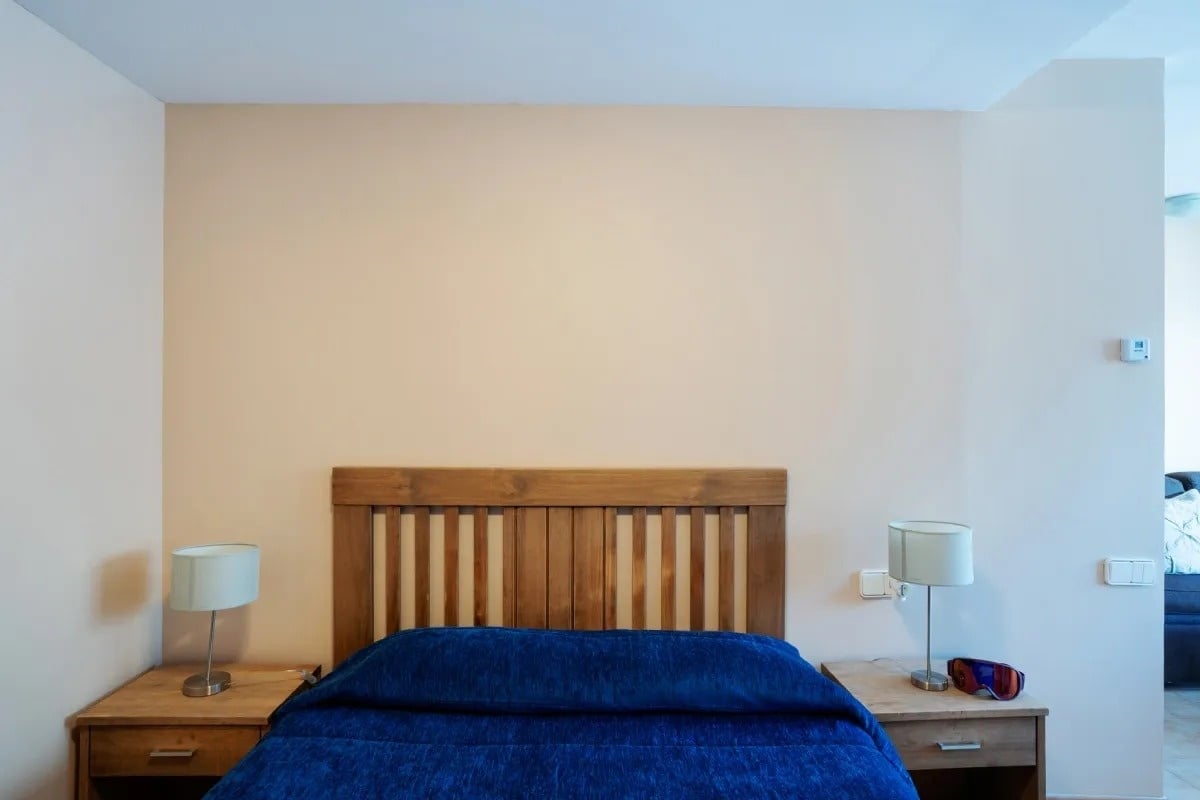 une chambre avec un lit bleu et deux lampes