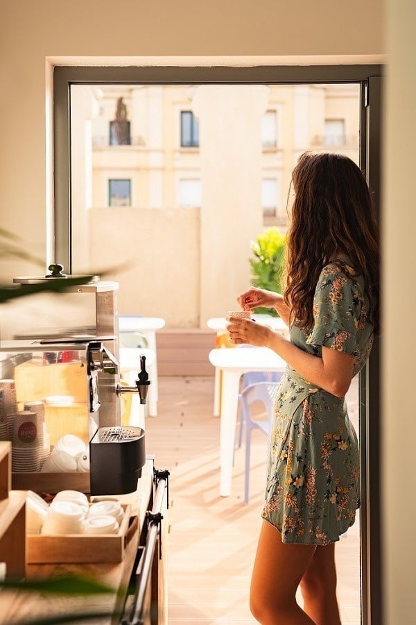 Woman enjoying a coffee at the Hotel Boutique Mosaic by Ona Hotels, in Barcelona