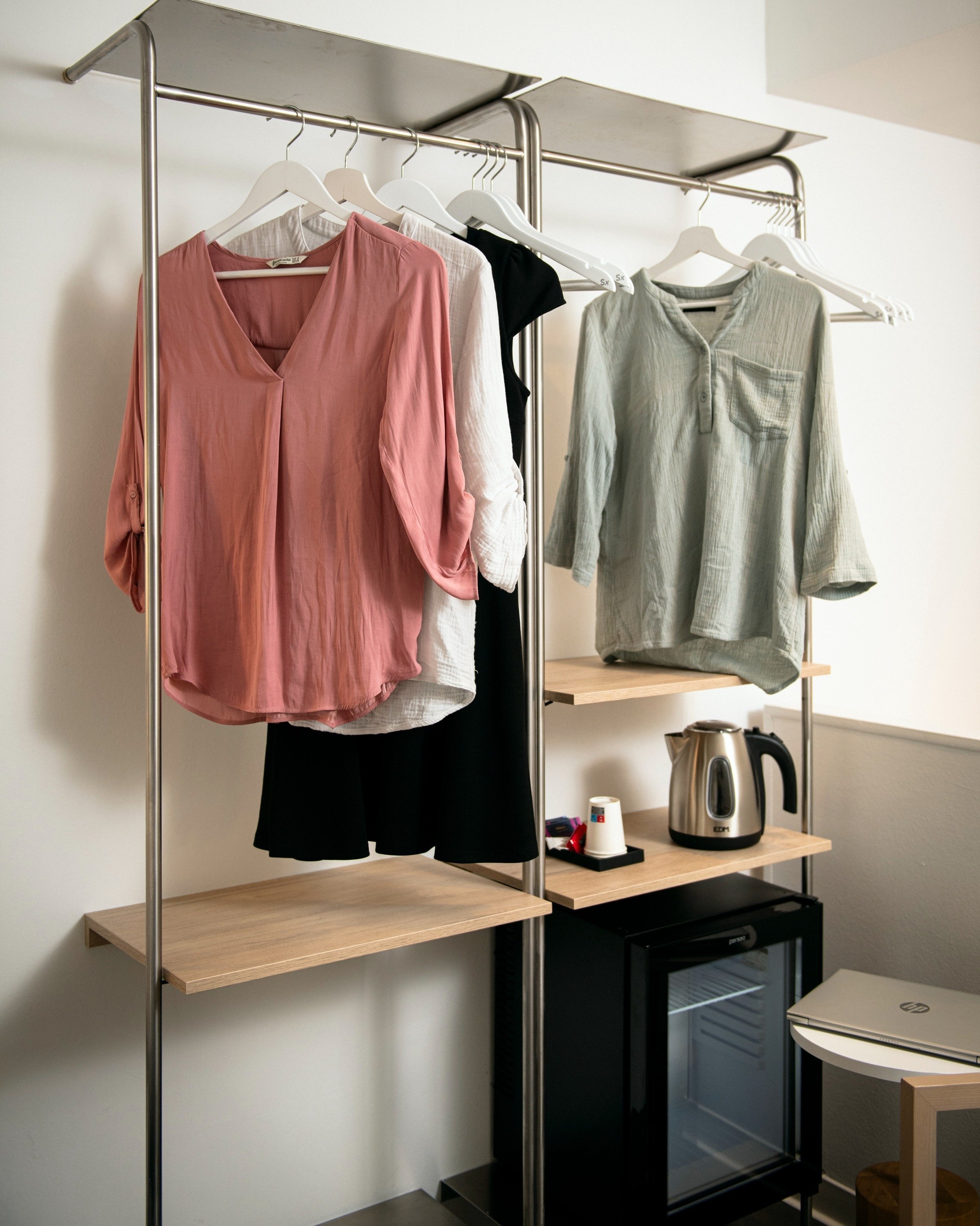 clothes hanging on a rack next to a kettle