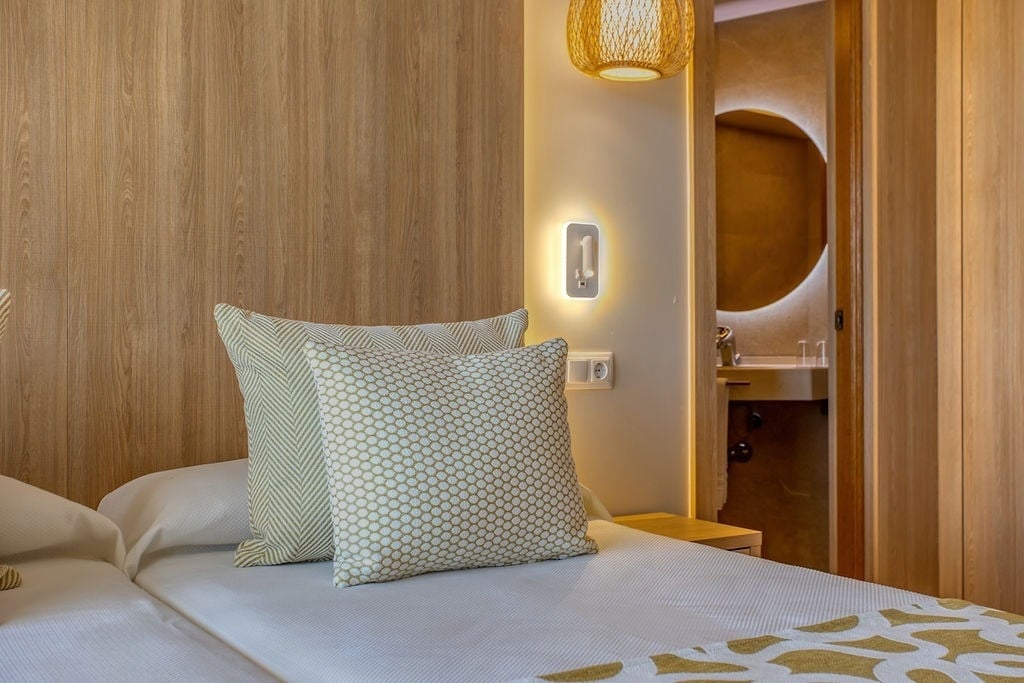 un lit avec des oreillers et un miroir dans une chambre d' hôtel