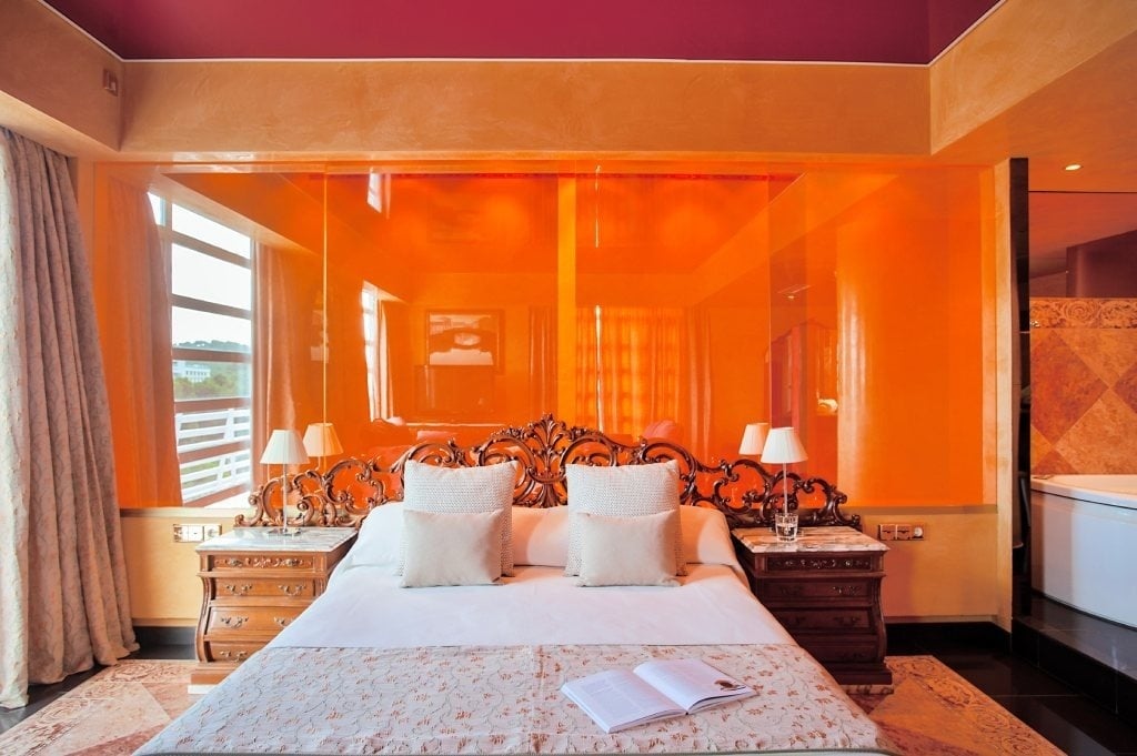 a bedroom with orange walls and a bed with a book on it