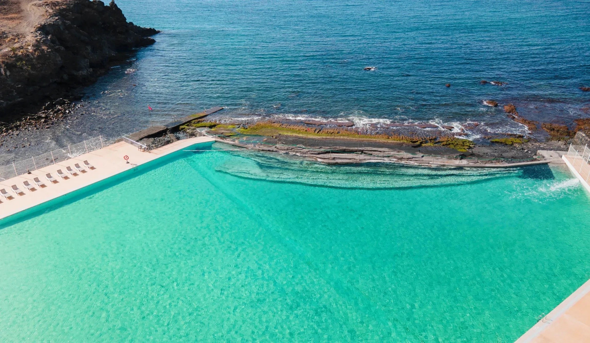 an aerial view of a swimming pool near the ocean