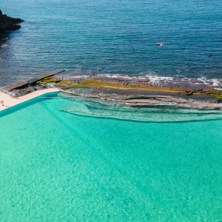 an aerial view of a swimming pool near the ocean