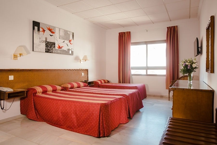 ein Hotelzimmer mit zwei Betten und einem Tisch