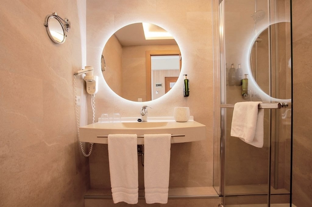 une salle de bain avec un lavabo et un miroir ovale