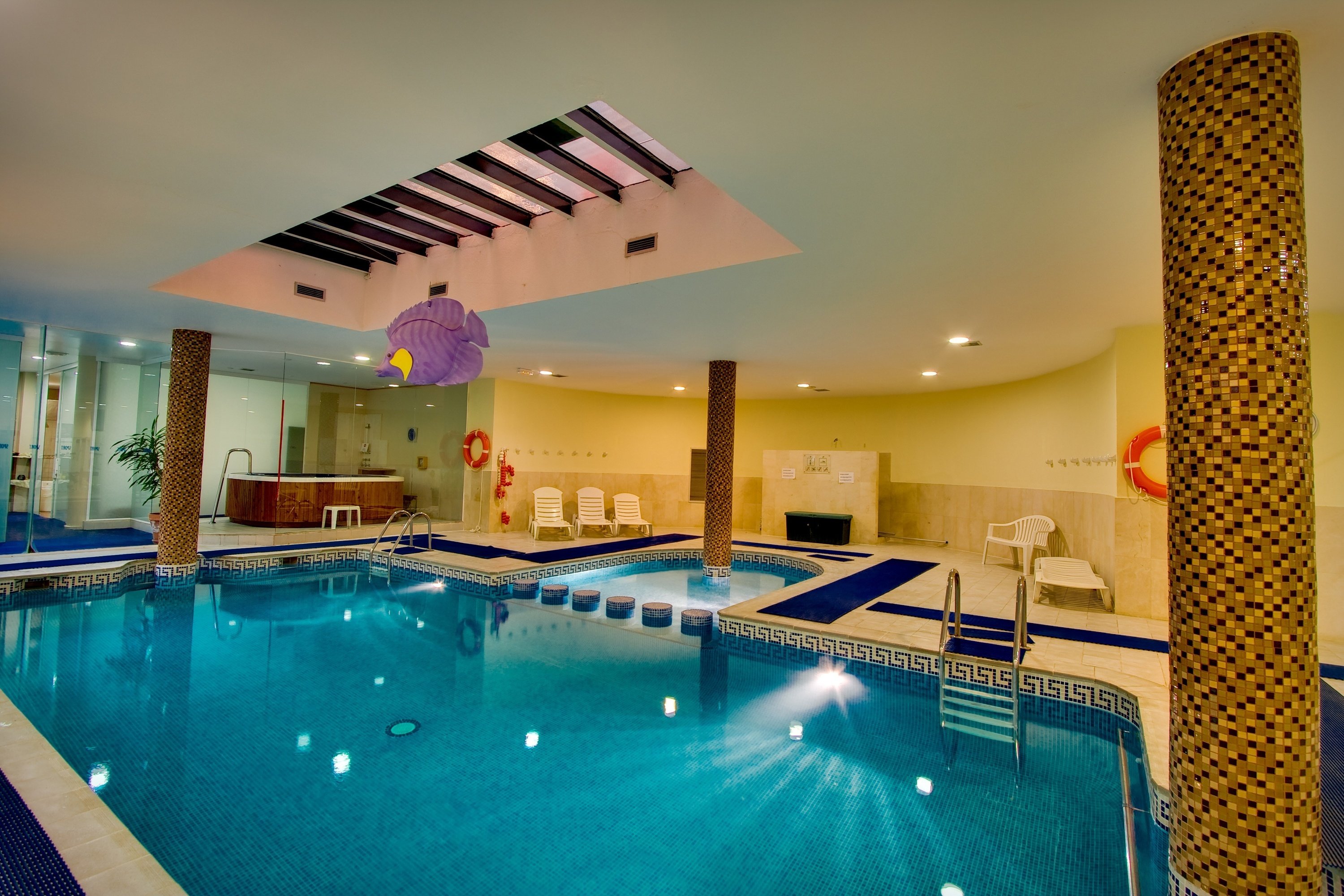 a large indoor swimming pool with a life preserver hanging from the ceiling