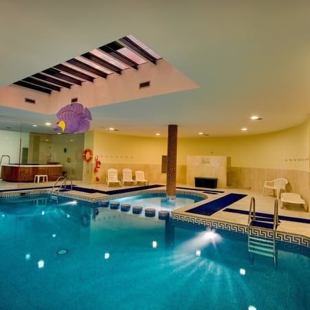 a large indoor swimming pool with a life preserver hanging from the ceiling