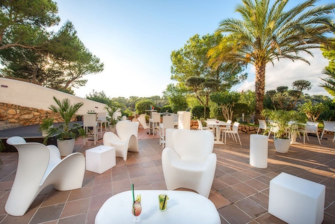 Terrace surrounded by palm trees of the Ona Cala Pi hotel, in Majorca