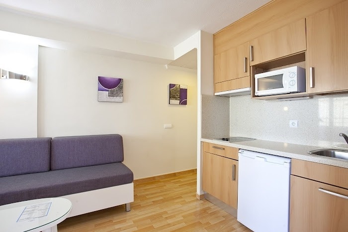 a kitchen with a purple couch and a microwave