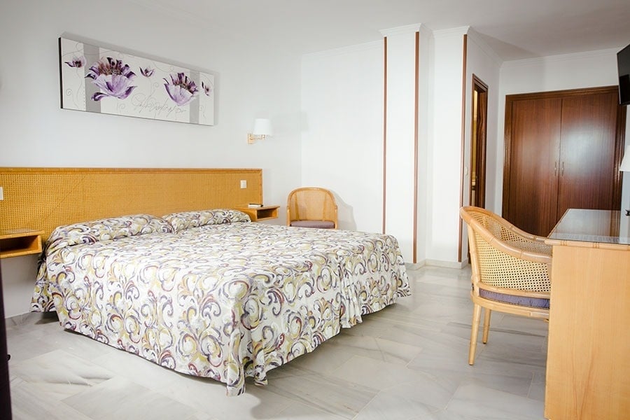 una habitación de hotel con una cama y una pintura en la pared